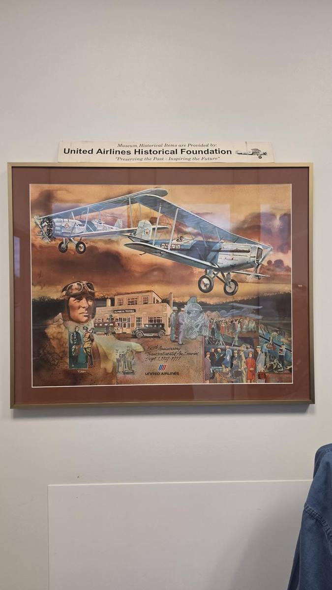Painting of a vintage biplane and airfield, presented by the Foundation