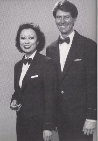 On International flights in all class of service, a waist length navy jacket with fitted styling was worn that was accented by one gold stri
