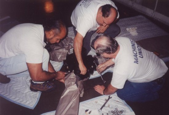 United Airlines’ Air Frame and Power Plant (A&P) mechanics Pete Lopez, Eric Driggs and Gary Young prepare the DC6B hub and propeller for ins