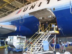 (Left) UAHF director Carole Tye strikes a pose under the engine of United’s B747 as she waits her turn to tour the aircraft. (Right) United 