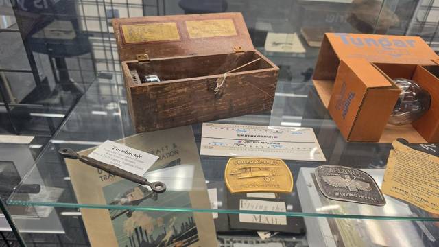 Tungar bulb in its box, a wooden case and belt buckles