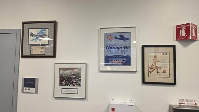 Framed posters and photographs on the exhibit wall